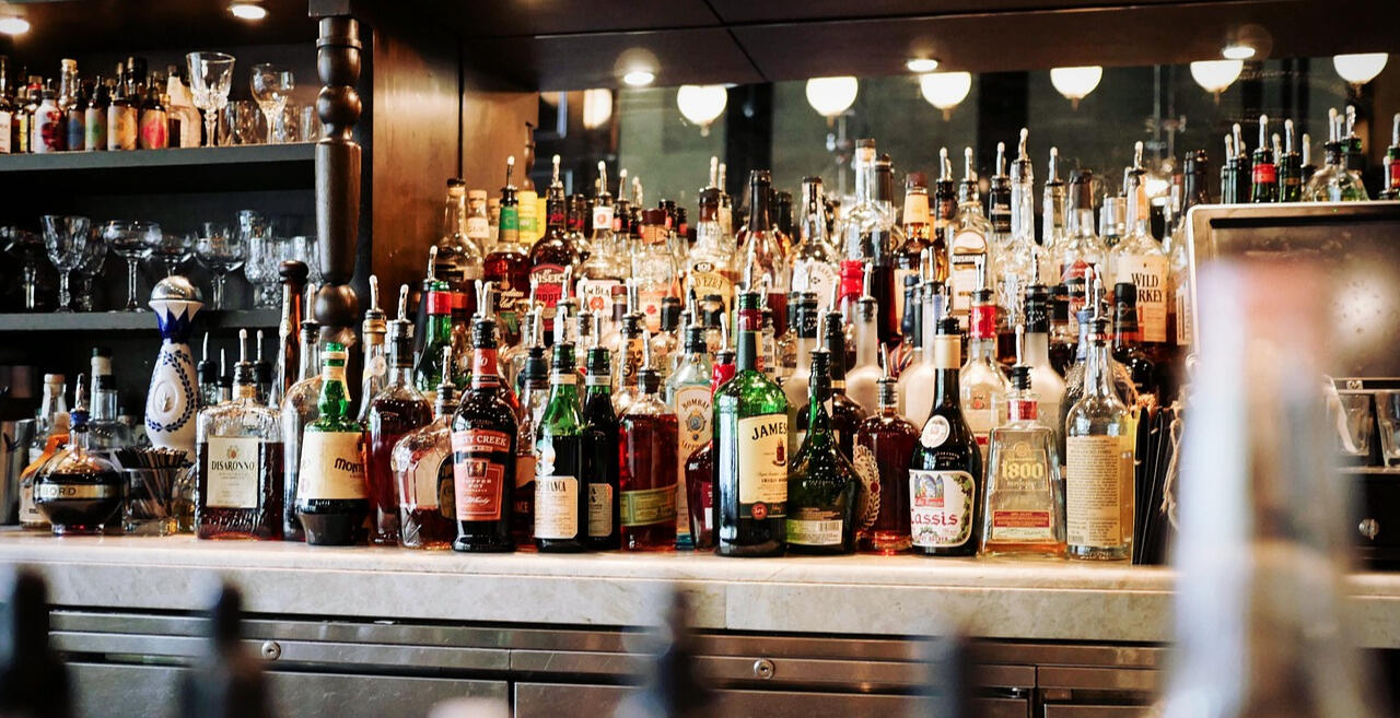 A photo of a bar with oodles of bottles of spirits etc in shot. Image courtesy of: Image by Pexels from Pixabay